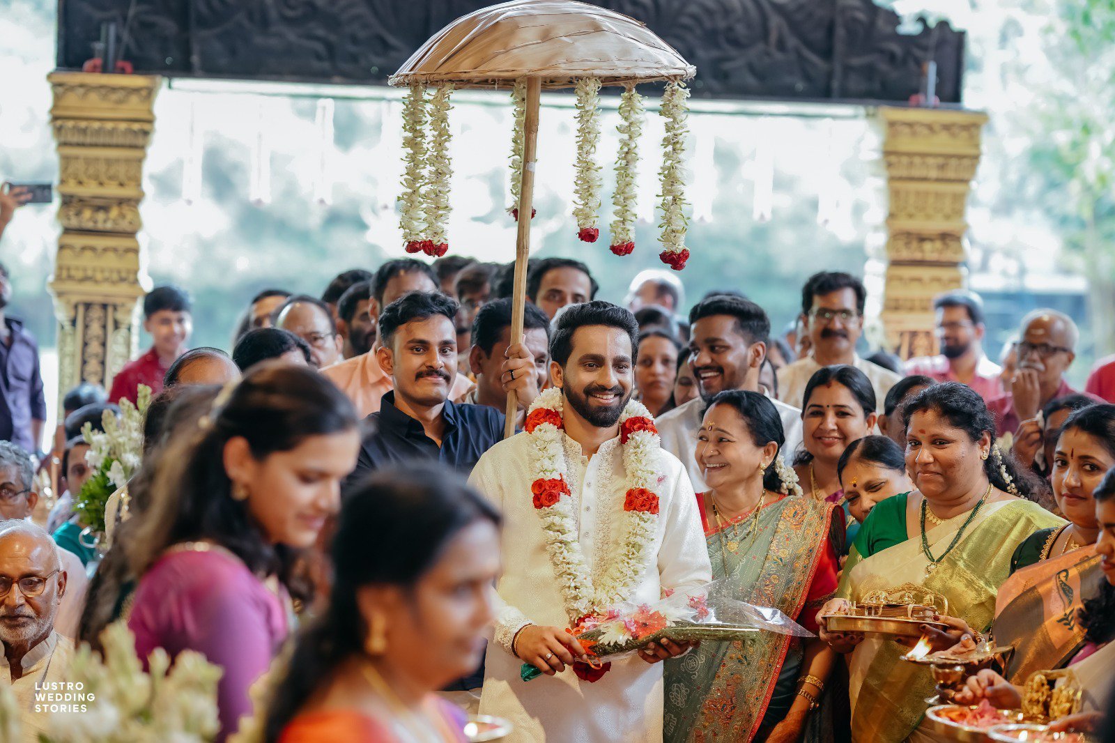 Guruvayur marriage booking - Joyful groom with family and relatives during the sacred procession at Guruvayur temple wedding ceremony