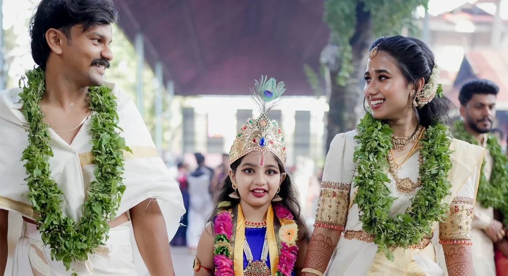 Guruvayoor wedding family moment with couple and child in traditional attire