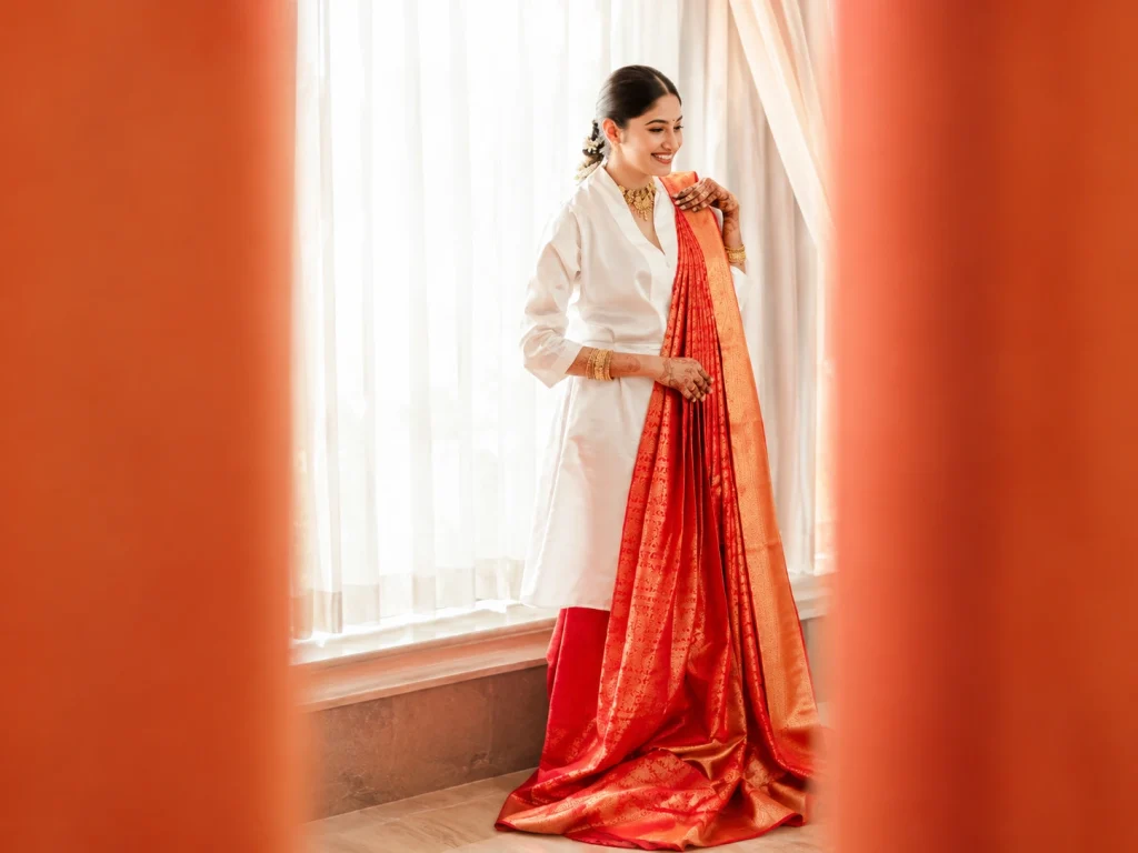 Bridal Makeup Guruvayur showcasing a bride in an elegant white and red traditional saree, gold jewelry, and beautifully styled bridal makeup.